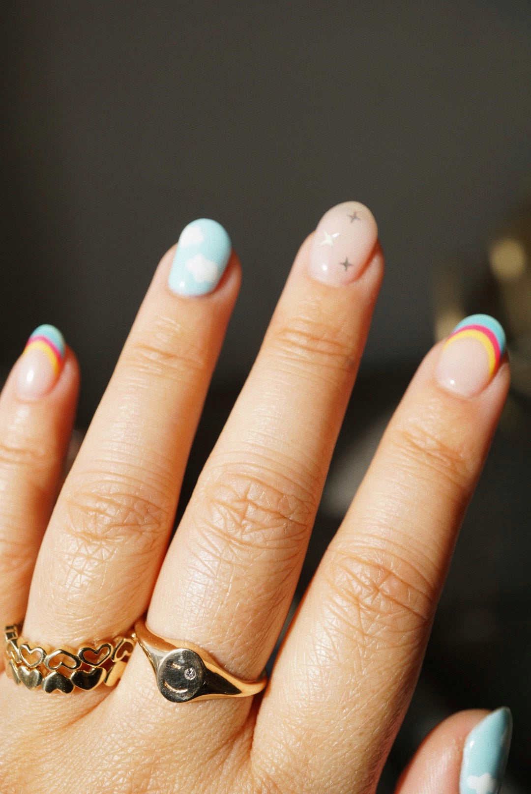 Hand with gold rings and fun nail art